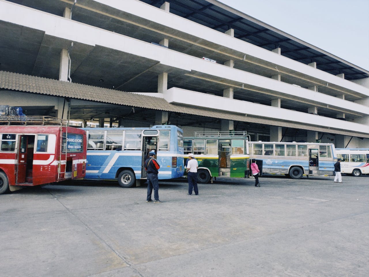 our-services-2 An urban bus station with several colorful buses parked, capturing public transportation in action.