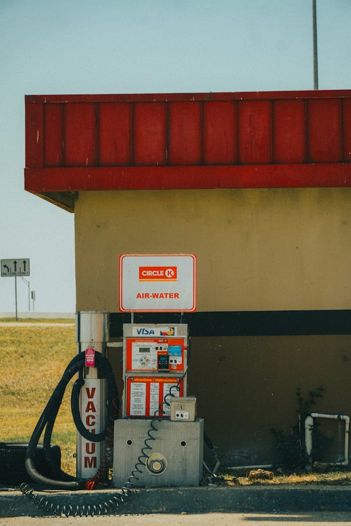about-01 Close-up of a gas station air-water pump and vacuum unit in a sunny outdoor setting.